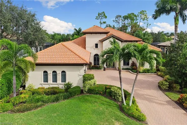 a view of a house with brick walls and a yard with plants