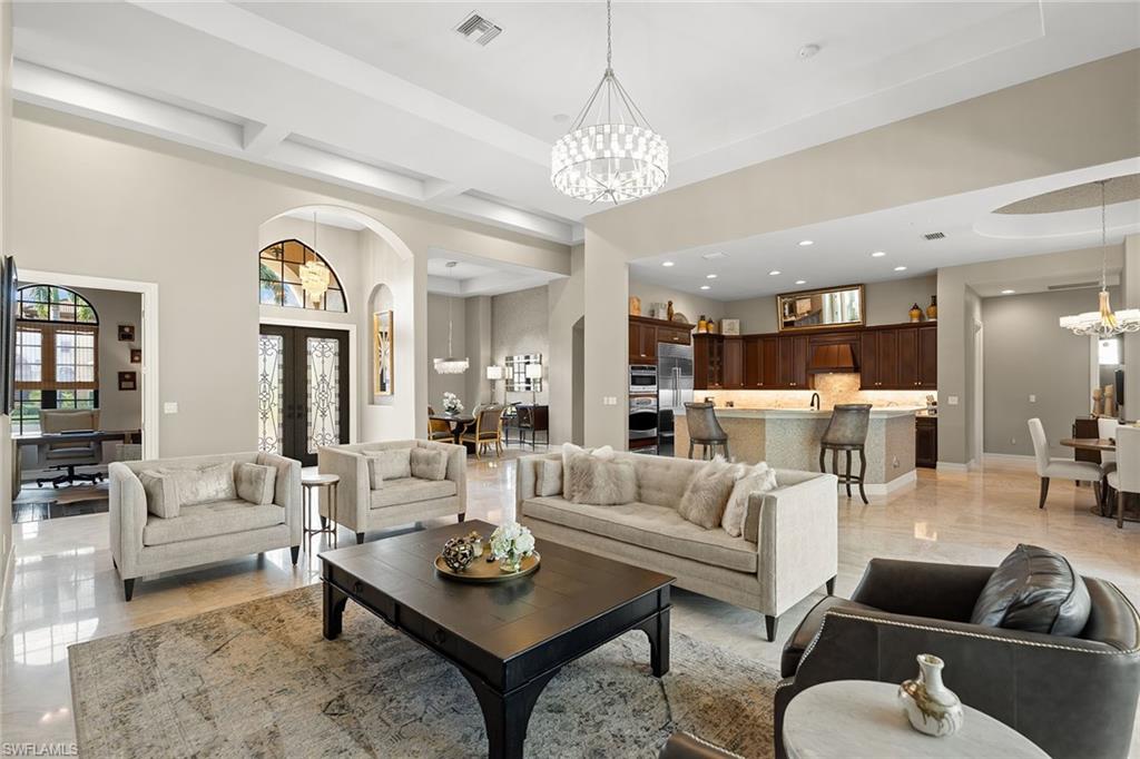 7400 Byrons Way Naples, FL 34113 - Photo 12 of 50 a living room with furniture kitchen view and a chandelier