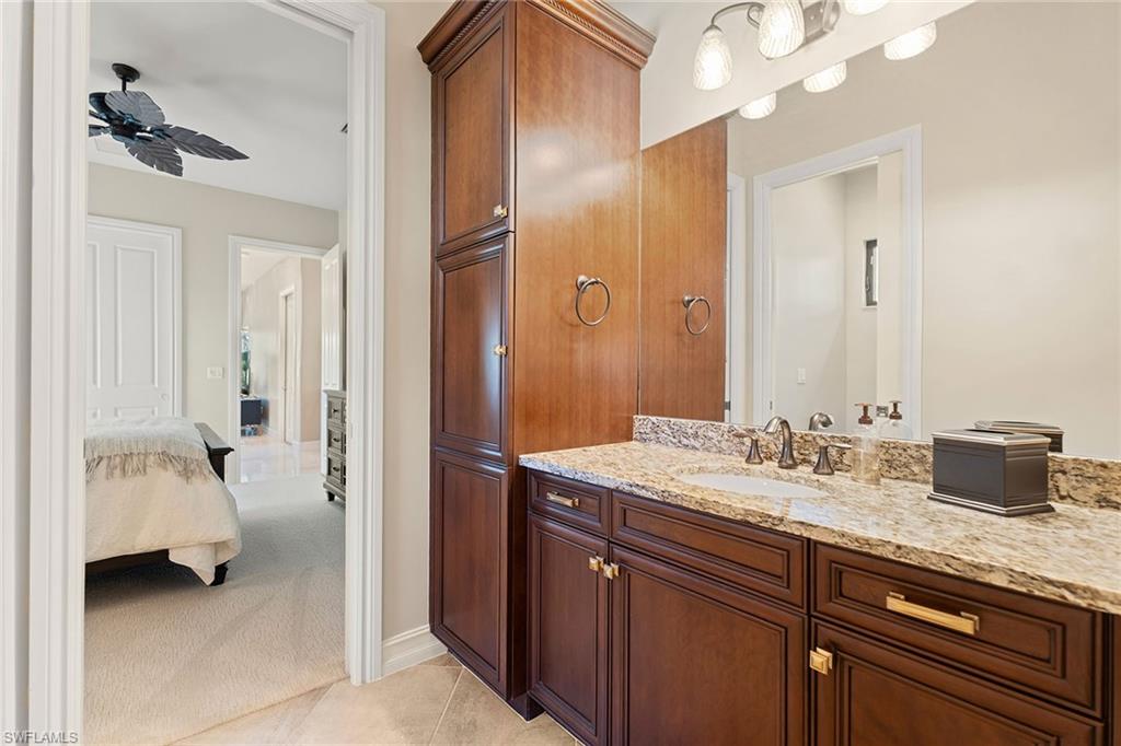 7400 Byrons Way Naples, FL 34113 - Photo 24 of 50 a en suite bathroom with a granite countertop sink and a mirror