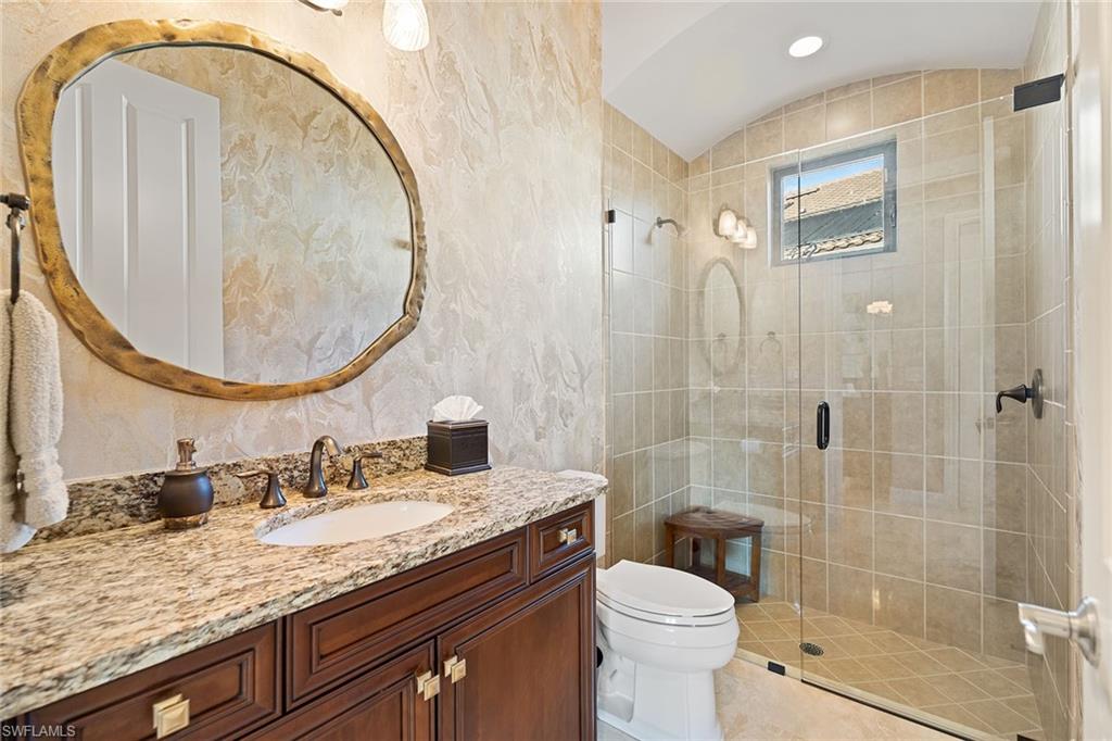 7400 Byrons Way Naples, FL 34113 - Photo 27 of 50 a bathroom with a granite countertop toilet a sink and a mirror