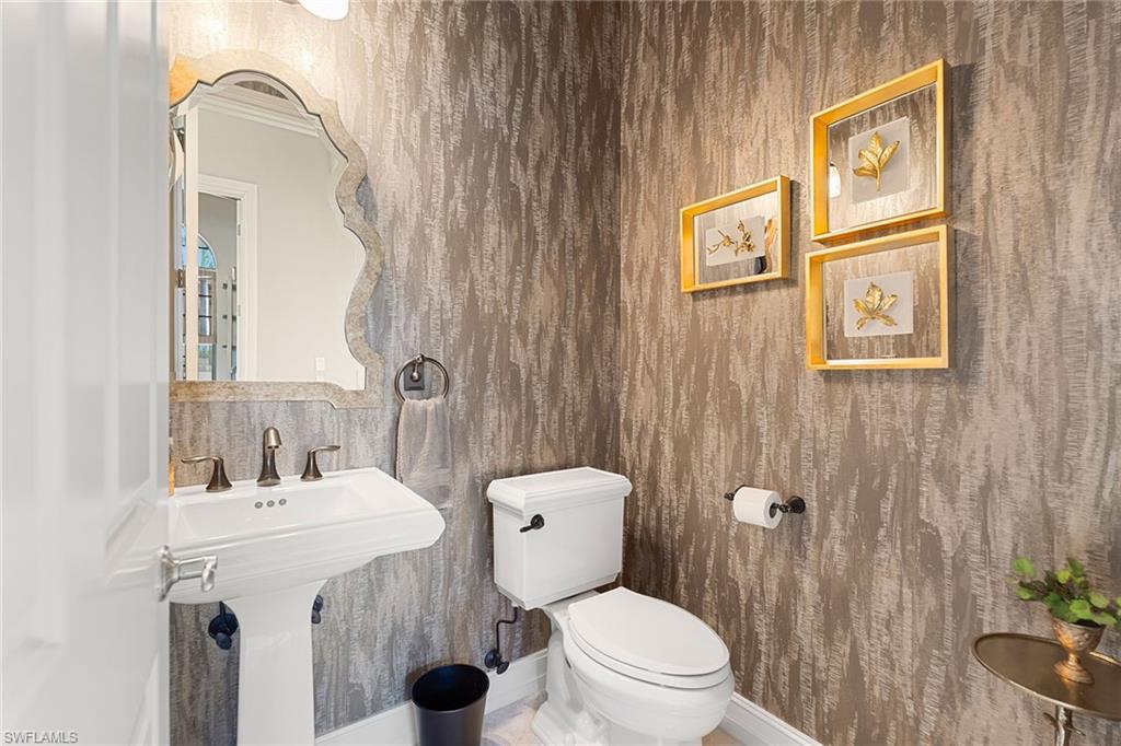 7400 Byrons Way Naples, FL 34113 - Photo 31 of 50 a bathroom with a granite countertop toilet sink and a mirror