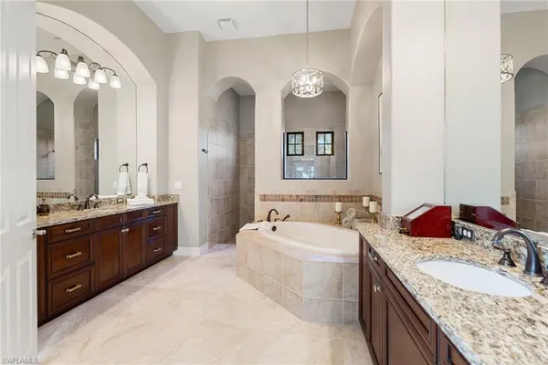 a spacious bathroom with a granite countertop double vanity sink and a mirror