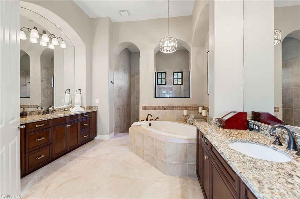 7400 Byrons Way Naples, FL 34113 - Photo 32 of 50 a spacious bathroom with a granite countertop double vanity sink and a mirror