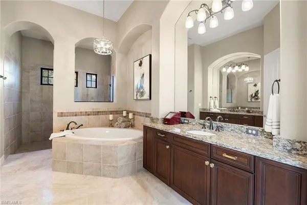a bathroom with a sink a large mirror and a bathtub