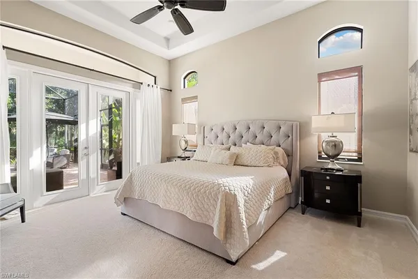 a spacious bedroom with a bed and a chandelier