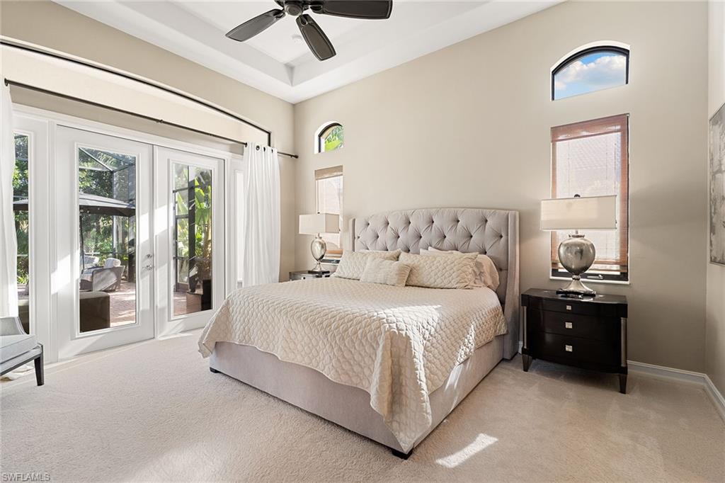 7400 Byrons Way Naples, FL 34113 - Photo 36 of 50 a spacious bedroom with a bed and a chandelier