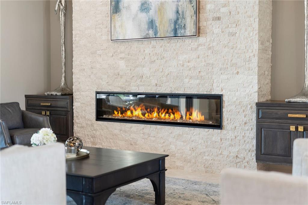 7400 Byrons Way Naples, FL 34113 - Photo 38 of 50 a room with a table chairs and fireplace