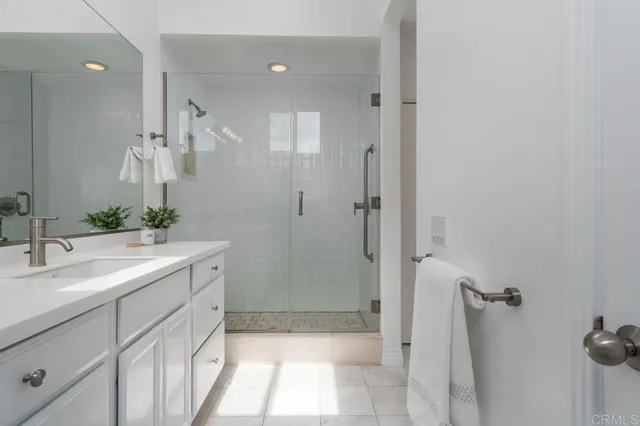a bathroom with a sink shower and a mirror