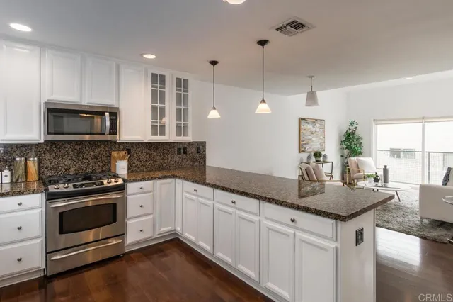 a kitchen with granite countertop stainless steel appliances a stove sink and microwave