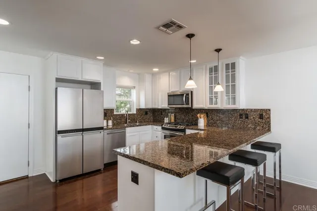 a kitchen with stainless steel appliances granite countertop a sink refrigerator and microwave