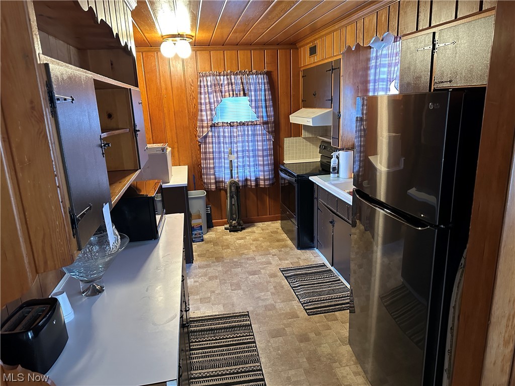 29 Grandview Road Cambridge, OH 43725 - Photo 10 of 32 Kitchen with wood ceiling, black appliances, wooden walls, and light tile floors