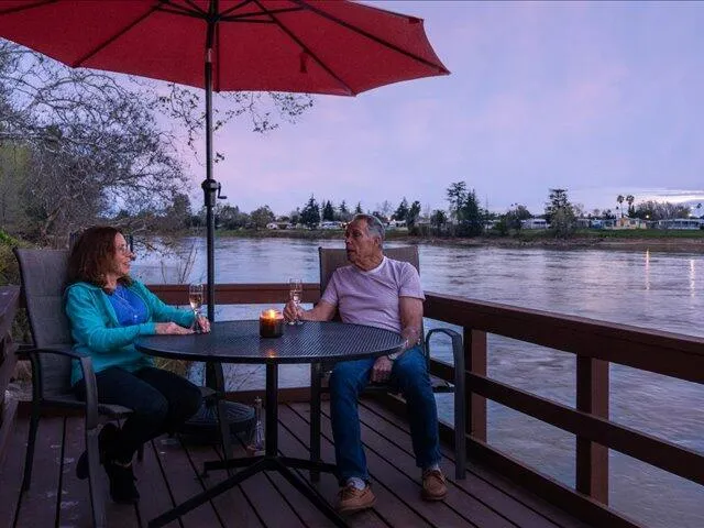 a view of a lake with table and chairs under an umbrella