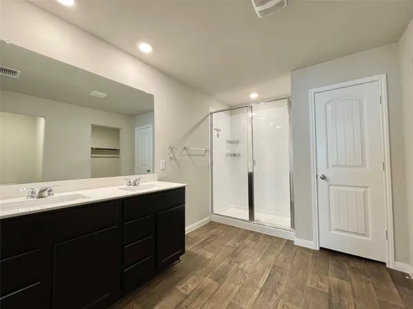 a bathroom with a double vanity sink mirror and shower