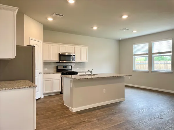 a kitchen with stainless steel appliances granite countertop a stove a sink and a refrigerator