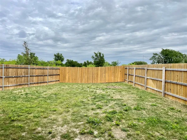 a view of a backyard with wooden fence