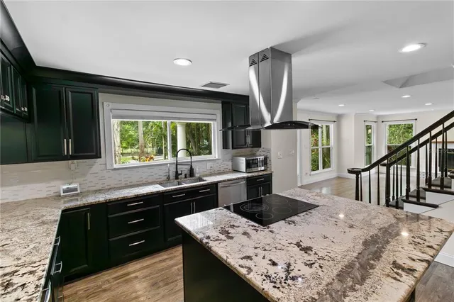a kitchen with granite countertop a sink and a stove