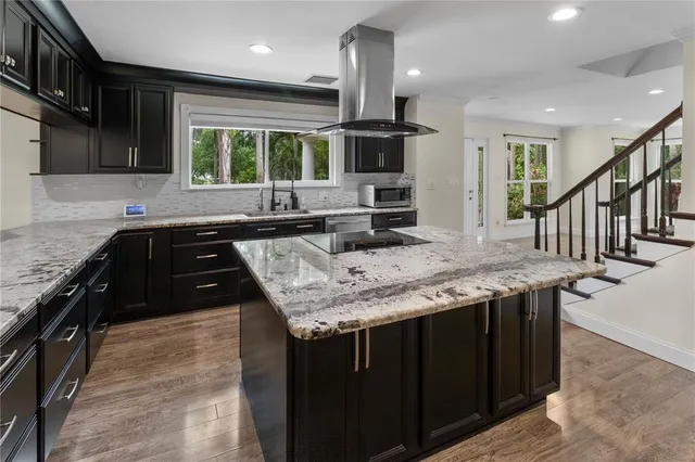 an empty room with wooden floor ceiling fan and windows