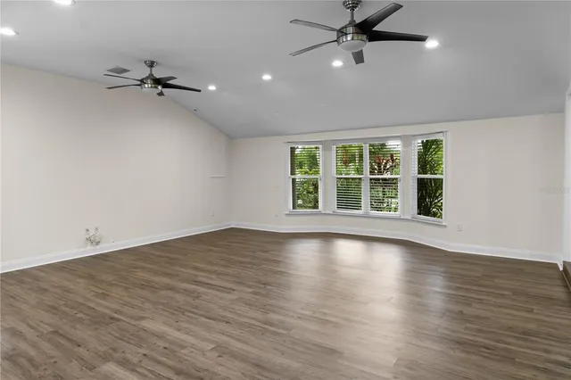 a bathroom with a granite countertop toilet a sink a window and mirror