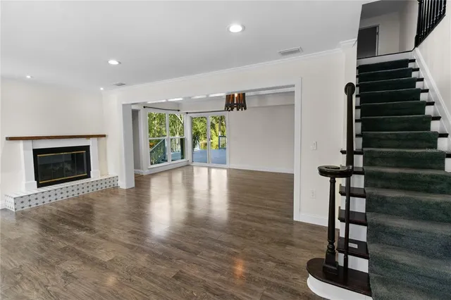 a view of an empty room with window and wooden floor
