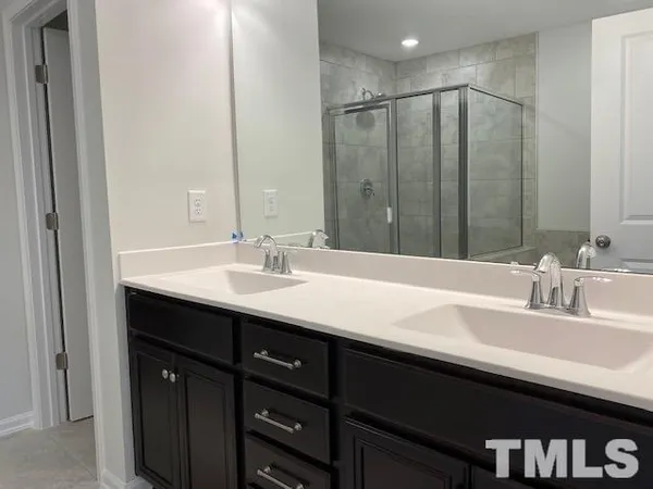a bathroom with double vanity sink and a mirror