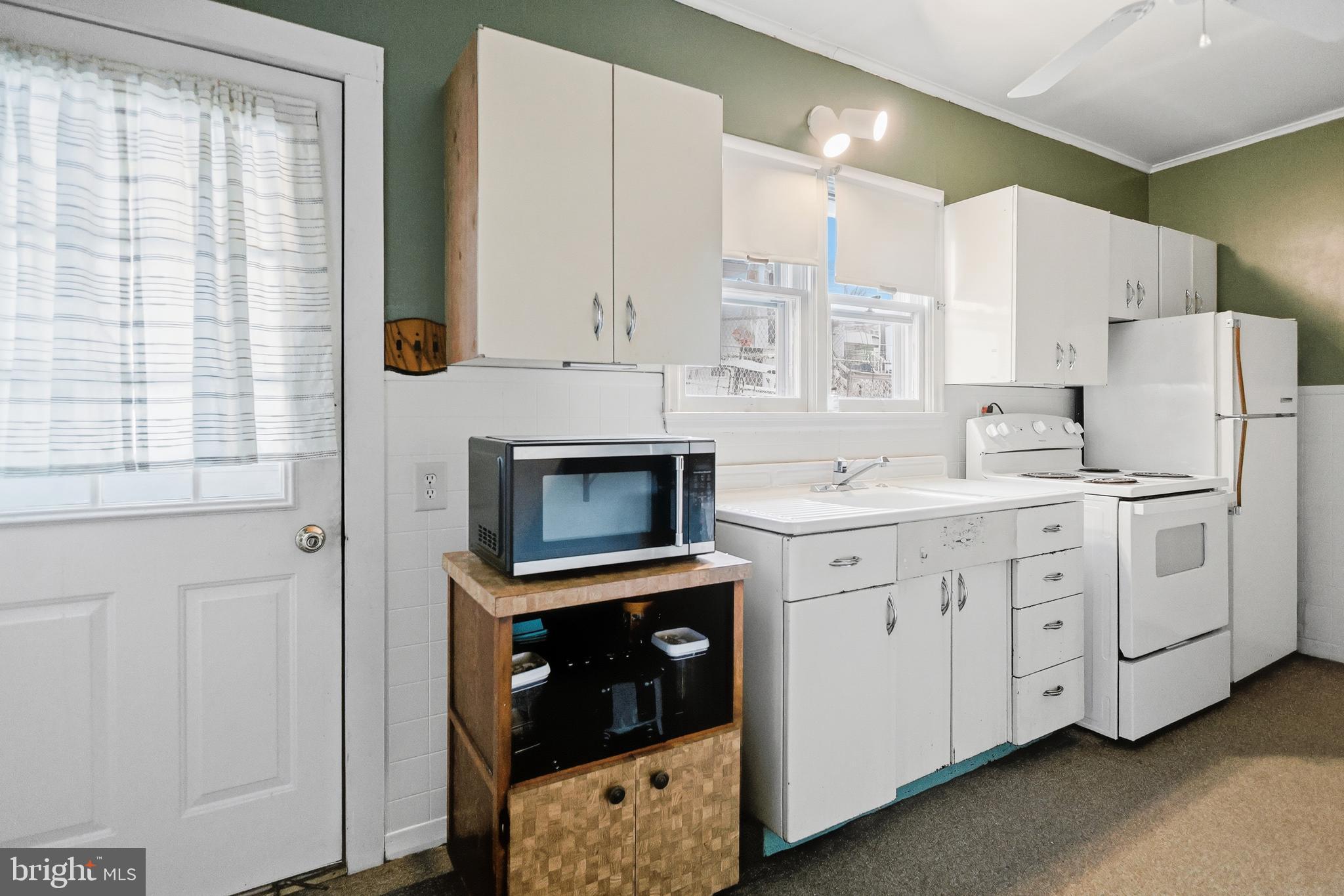728 East Broad Street Tamaqua, PA 18252 - Photo 12 of 26 a kitchen with white cabinets and white appliances