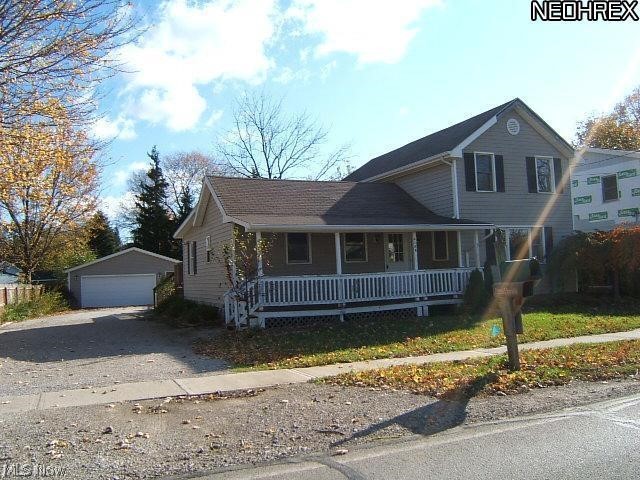 4185 Maple Street Perry, OH 44081 - Photo 2 of 2 View of front facade with covered porch, an outdoor structure, and a detached garage