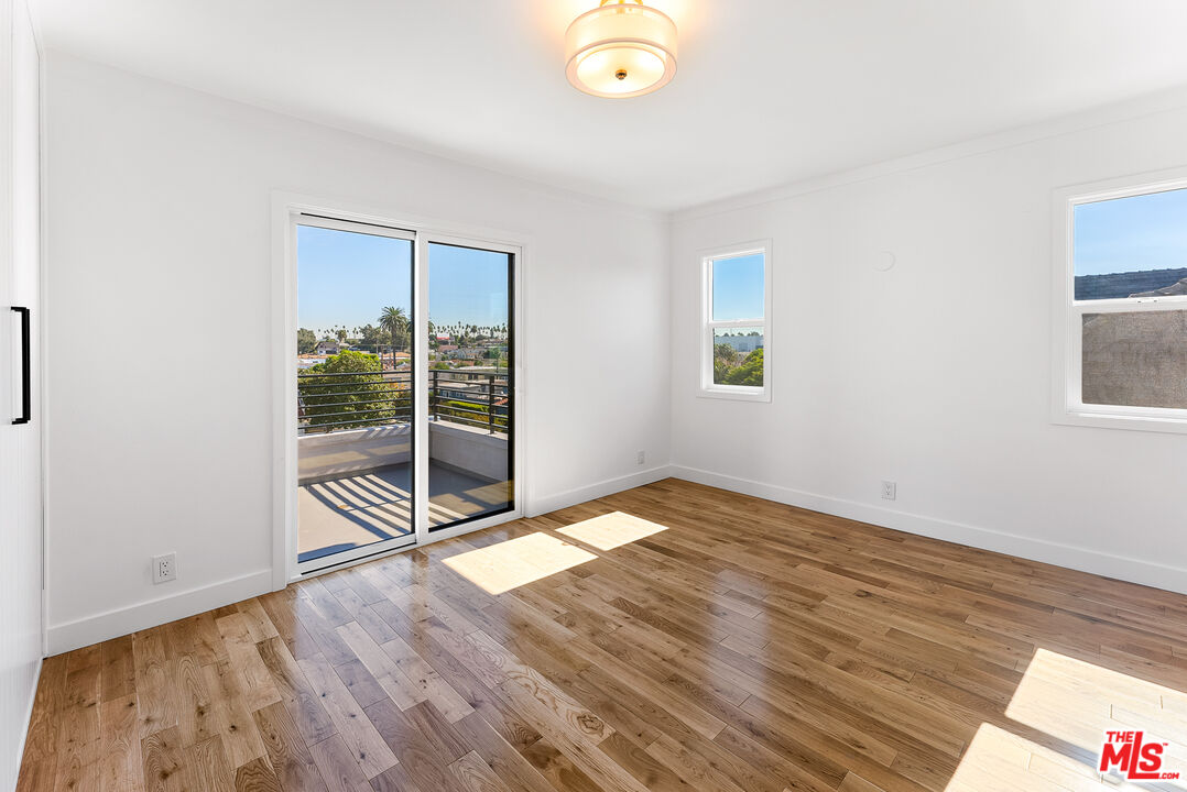 1253 South Rimpau Boulevard Los Angeles, CA 90019 - Photo 33 of 71 a view of an empty room with wooden floor and a window