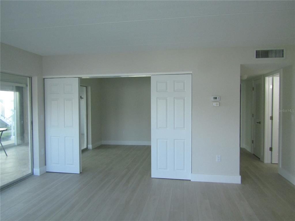 999 Inlet Circle, Unit D101 Venice, FL 34285 - Photo 11 of 29 an empty room with wooden floor and windows