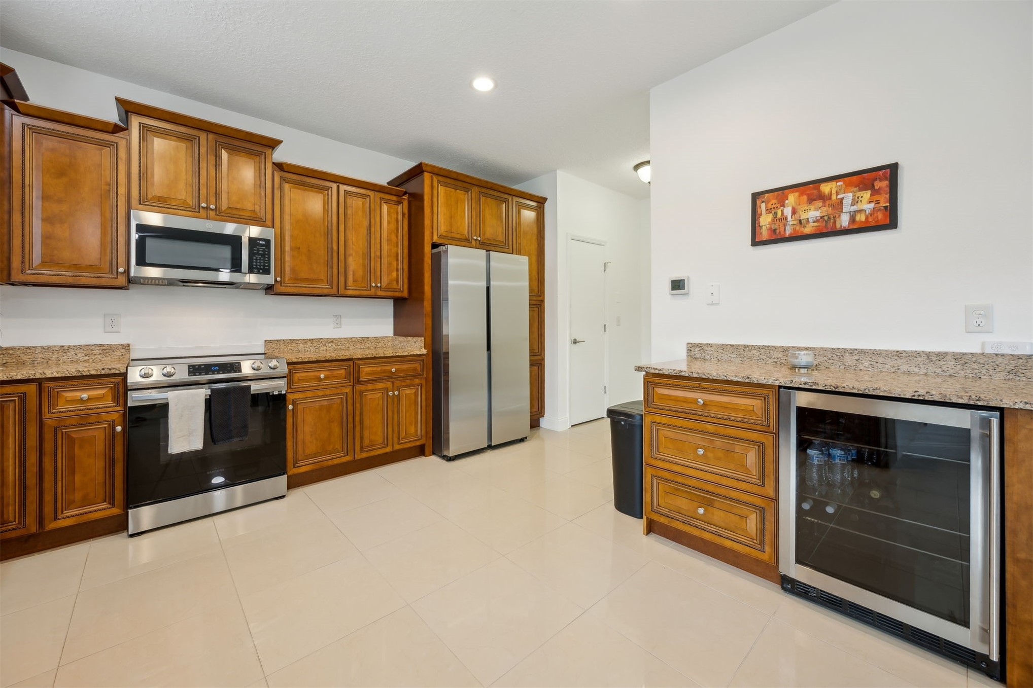 76002 Tideview Lane Yulee, FL 32097 - Photo 18 of 58 a kitchen with stainless steel appliances granite countertop a stove top oven a sink dishwasher and a refrigerator with wooden cabinets