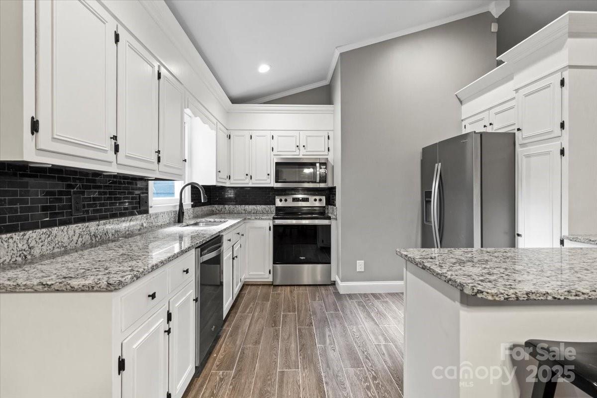 7918 Sarah Drive Denver, NC 28037 - Photo 11 of 31 a kitchen with stainless steel appliances granite countertop a stove and a refrigerator