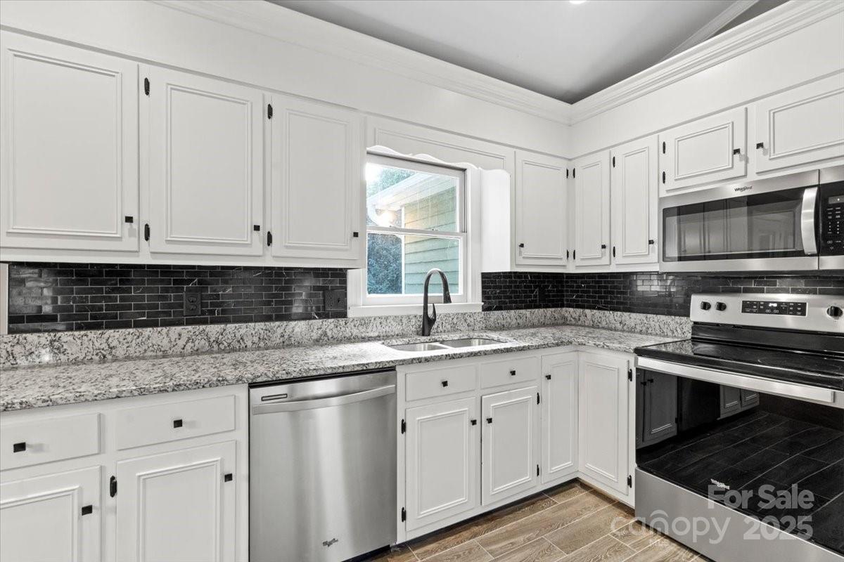 7918 Sarah Drive Denver, NC 28037 - Photo 12 of 31 a kitchen with granite countertop white cabinets stainless steel appliances and a sink