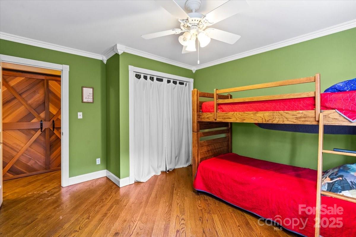 7918 Sarah Drive Denver, NC 28037 - Photo 16 of 31 a bedroom with a bed and a chandelier