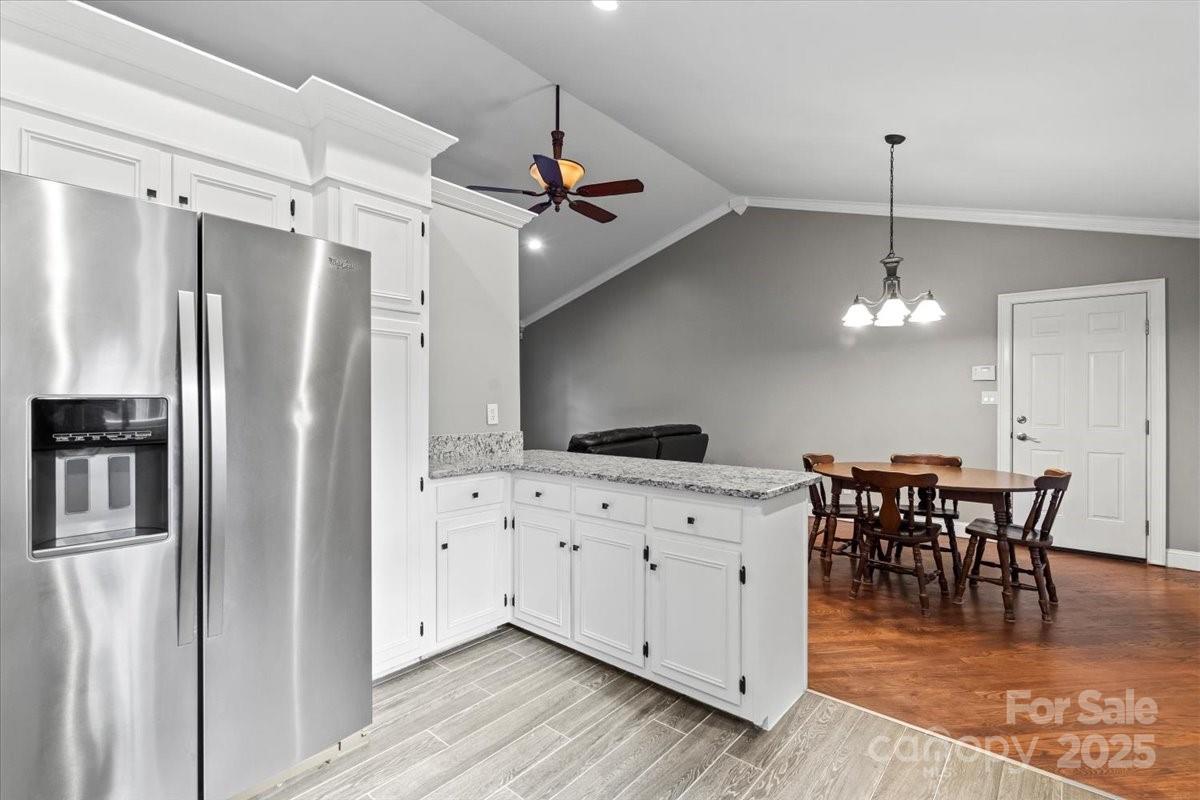 7918 Sarah Drive Denver, NC 28037 - Photo 10 of 31 a kitchen with stainless steel appliances granite countertop a refrigerator a sink dishwasher a dining table and chairs with wooden floor