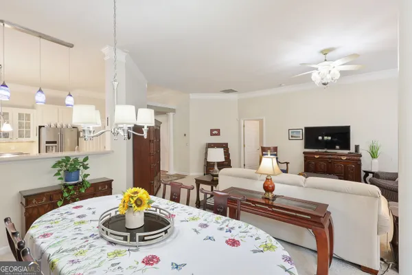 a living room with furniture and a dining table with wooden floor