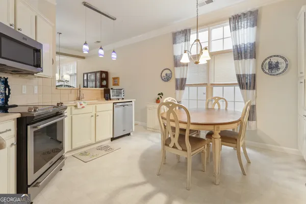 a kitchen with a table chairs microwave and cabinets