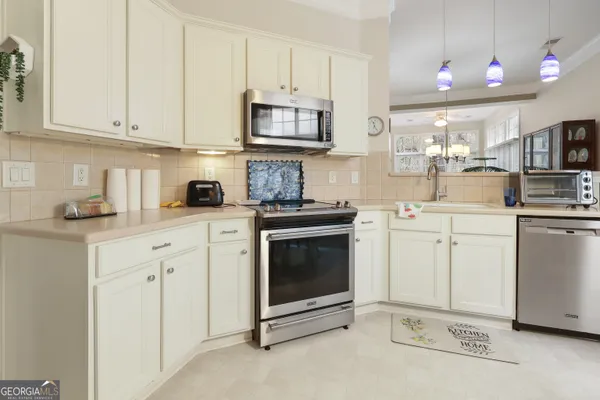 a kitchen with white cabinets and white appliances