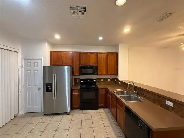 a large kitchen with granite countertop a stove and a refrigerator