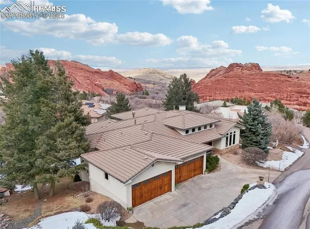 an aerial view of a house with a mountain