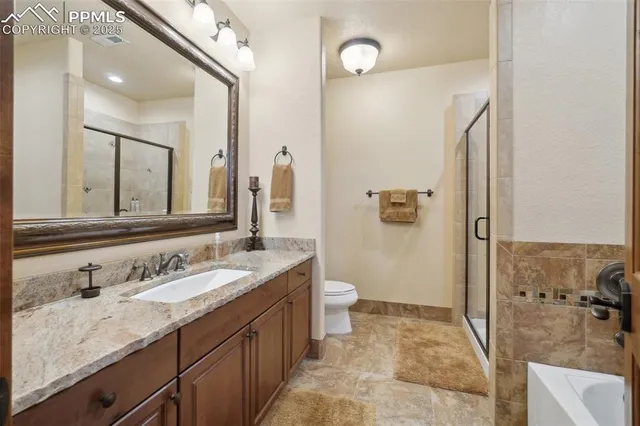 a bathroom with a granite countertop sink a mirror and shower