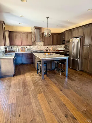 a kitchen with stainless steel appliances wooden floors and wooden cabinets