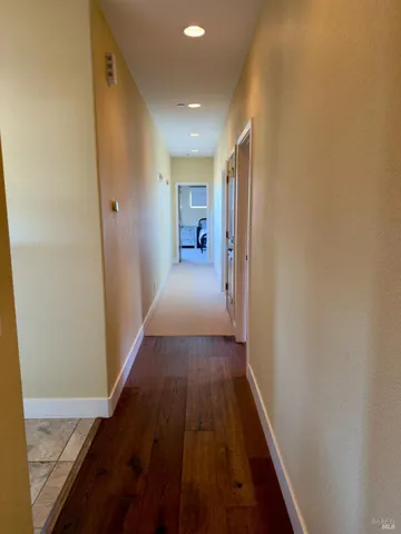 a view of a hallway with wooden floor