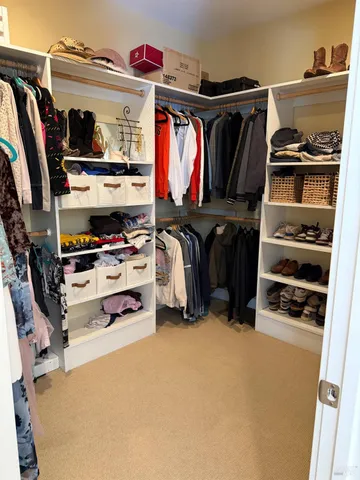 a view of walk in closet with clothes and shoes