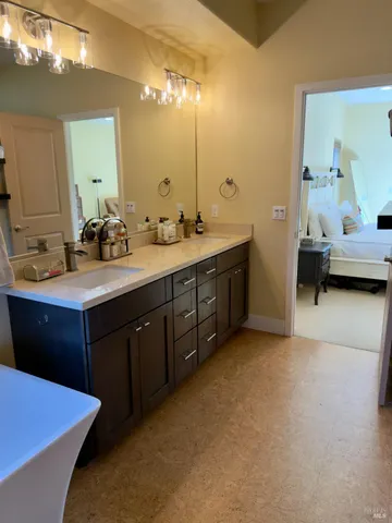 a en suite bathroom with a double vanity sink and a mirror