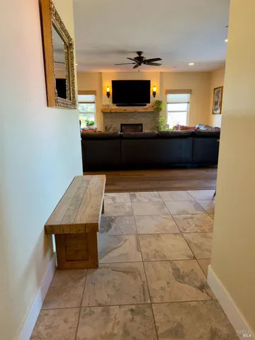 a living room with stainless steel appliances kitchen island granite countertop a sink and a black cabinets