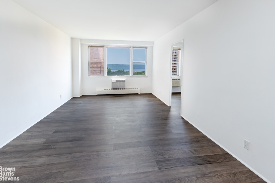 5700 Arlington Avenue, Unit 11X Bronx, NY 10471 - Photo 2 of 21 an empty room with wooden floor and windows