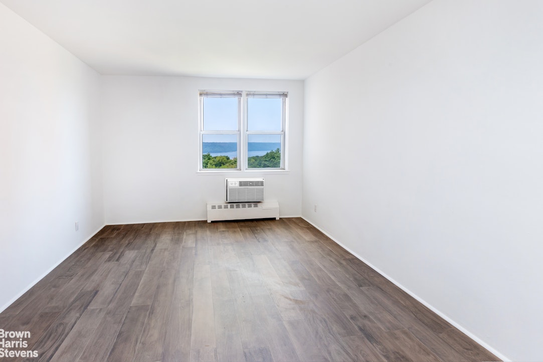 5700 Arlington Avenue, Unit 11X Bronx, NY 10471 - Photo 7 of 21 a view of an empty room with wooden floor and a window