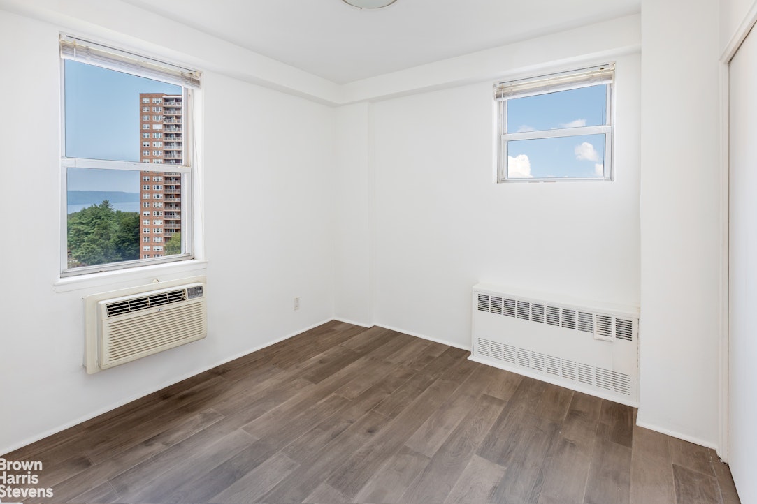 5700 Arlington Avenue, Unit 11X Bronx, NY 10471 - Photo 9 of 21 an empty room with wooden floor and windows
