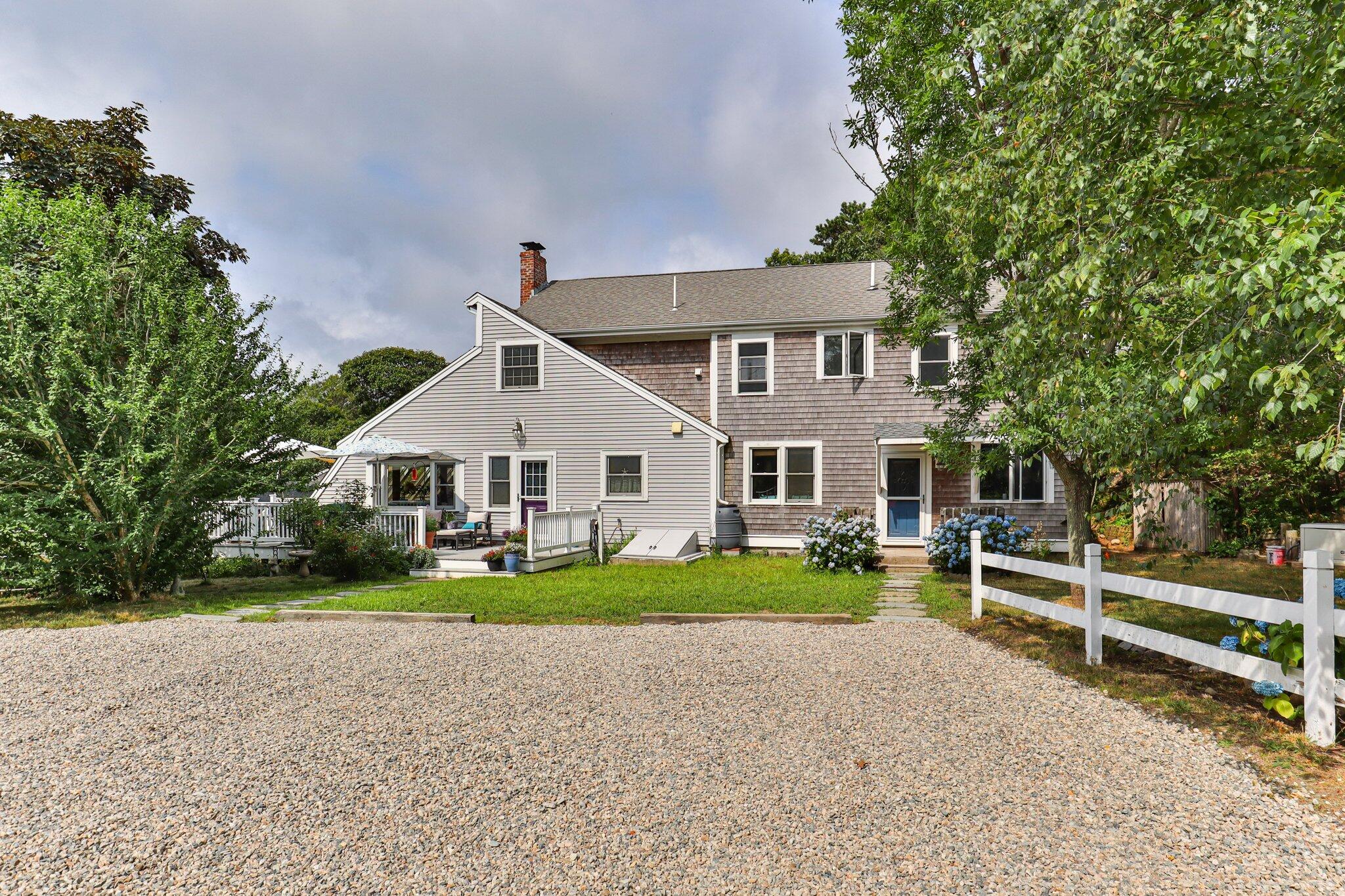 a view of a house with a yard and large tree