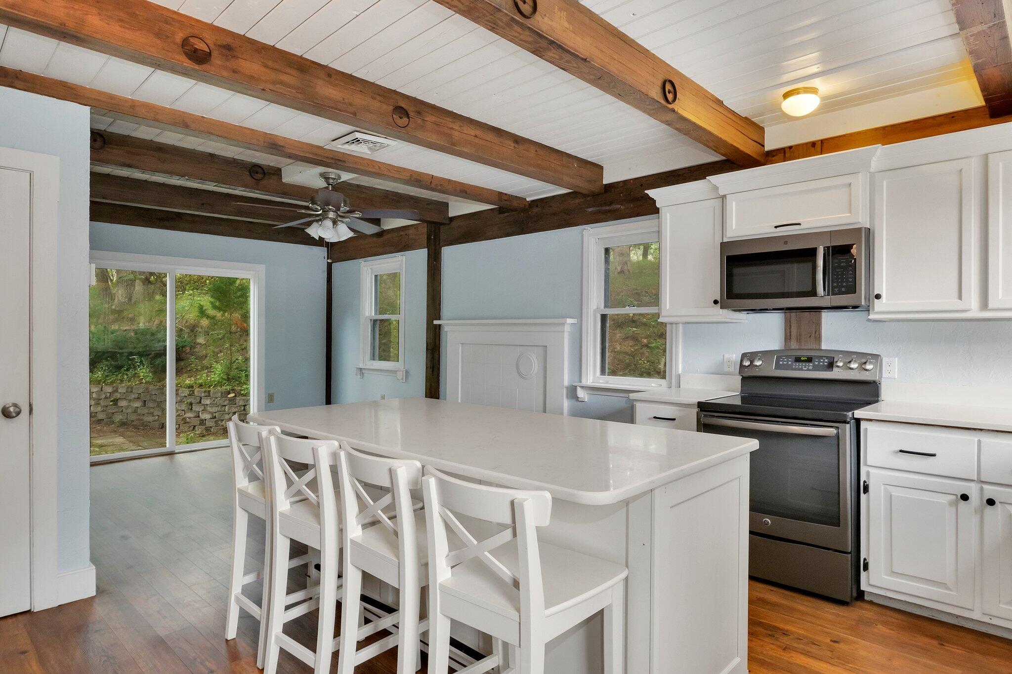 36 Bakers Pond Road Orleans, MA 02653 - Photo 26 of 50 a kitchen with a table chairs microwave and cabinets