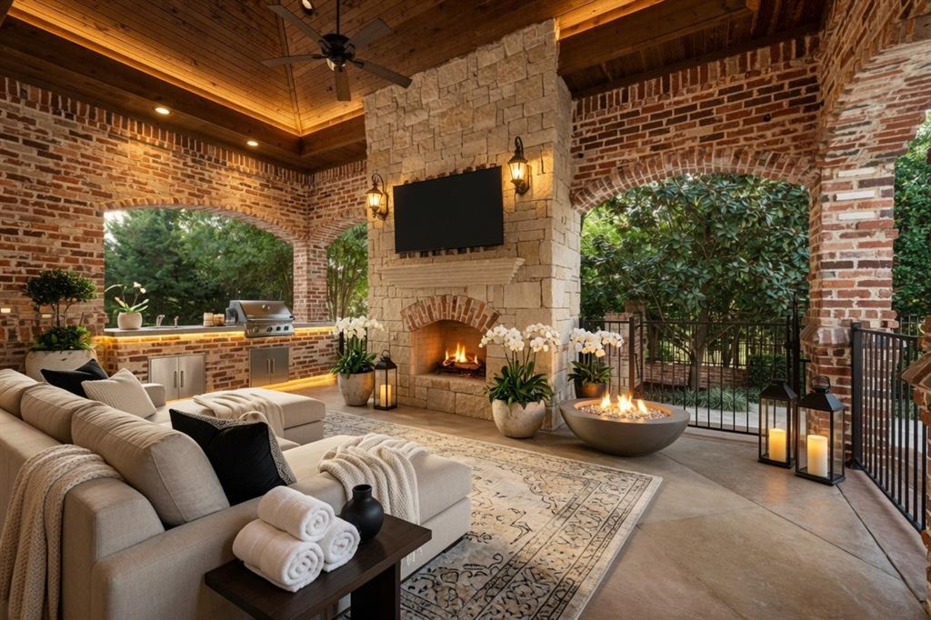 6900 Rockingham Court Colleyville, TX 76034 - Photo 33 of 40 Covered Patio #2 of 4 and outdoor kitchen off of main kitchen features a stone fireplace with a mounted television, a ceiling fan, BBQ Grill, Refrigerator, and a wood-paneled vaulted ceiling. Ai staged.